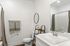 Elegant bathroom with modern fixtures, a spacious vanity, and stylish ladder shelving.
