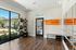 Bright home yoga studio with elegant mirrors, natural light from large windows, and vibrant fitness equipment.