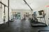 Modern fitness center featuring state-of-the-art equipment, large windows, and views of a sunny poolside area.