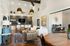 Stylishly designed living area featuring modern decor with cozy armchairs, elegant pendant lighting, and a chic coffee bar backdrop.