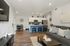 Modern living area with sleek kitchen, elegant dining space, and cozy seating. Natural light and stylish decor enhance the open plan.