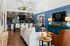 Inviting living area with modern decor, featuring a stylish white sofa, vibrant accent wall, and sleek kitchen with sophisticated lighting.