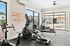 Inviting fitness center with modern exercise equipment, vibrant motivational wall art, and a view of the sparkling pool area through large windows.