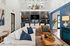Luxurious open-concept living area with elegant decor, featuring a sleek black-tiled backsplash, cozy seating, and chic contemporary lighting.