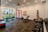 Modern and vibrant apartment gym with high-end equipment, large windows, and motivational decor, offering a perfect space for fitness enthusiasts.
