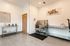Bright and welcoming pet spa room with stylish subway tile, stainless steel wash station, and playful cat art, perfect for pampering pets.