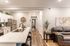 Chic modern kitchen and cozy living area with a sleek countertop, stylish decor, and warm wooden flooring.