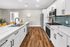 Bright kitchen with quartz countertops, white cabinets, and subway tile backsplash.