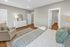 Spacious bedroom with natural light, neutral decor, king-size bed, and modern furnishings.