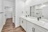Bathroom with double sinks, quartz counters, and walk-in closet.