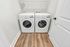 In-unit side-by-side modern washer and dryer with storage space.
