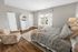 Spacious bedroom with natural light, neutral decor, king-size bed, and modern furnishings.