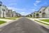 Modern townhomes on a residential street with landscaped sidewalks.