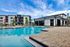 Inviting outdoor pool area with modern lounge chairs, vibrant umbrellas, and a spacious sun deck, perfect for relaxation and leisure.