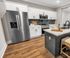 Modern kitchen featuring sleek stainless steel appliances, elegant white cabinetry, stylish subway tile backsplash, and a chic island with bar seating.