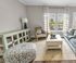 Bright and inviting living room with elegant decor, featuring a cozy sofa, stylish armchair, and a view of serene outdoor scenery through large windows.