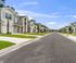 Charming suburban street lined with modern, two-story homes under a bright blue sky, perfect for family living.