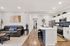 Modern open-plan living room with sleek sofa, stylish kitchen island, and contemporary cabinetry. Perfect for comfortable living and entertaining.