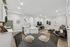 Inviting open-concept kitchen and living area with sleek white cabinetry, modern appliances, and stylish decor, ideal for entertaining.