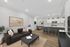Modern open-concept living area with a cozy black sofa, stylish kitchen island, and elegant dining nook, perfect for entertaining.