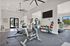 Modern fitness center featuring state-of-the-art exercise bikes, colorful kettlebells, and large windows for a bright workout environment.