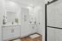 Elegant bathroom design featuring dual vanity with sleek white cabinetry, illuminated mirrors, and modern black fixtures.