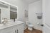 Modern bathroom with elegant white vanity, sleek LED mirror, and chic wall art, showcasing a sophisticated and serene atmosphere.