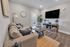 Inviting living room with plush sofa, elegant decor, and large wall-mounted TV, perfect for relaxation and entertainment.