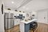 Modern kitchen with sleek stainless steel appliances, stylish white cabinetry, and a spacious island with bar seating.