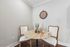 Chic dining nook with a round marble table, elegant chairs, and a stylish wall clock, perfect for intimate conversations.