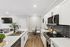 Contemporary kitchen with sleek white cabinetry, elegant countertops, and a cozy dining nook, perfect for modern living.