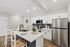Chic and modern kitchen featuring sleek stainless steel appliances, an elegant island with seating, and stylish cabinetry.