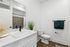 Elegant bathroom with a modern white vanity, sleek black fixtures, and stylish decor accents.