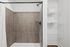 Elegant bathroom with modern shower, sleek brown tiles, and organized shelving, creating a spa-like retreat.