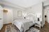 Charming bedroom with elegant decor, featuring a cozy bed, stylish nightstand, and a spacious walk-in closet.