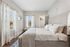 Bright and airy bedroom with elegant decor, featuring large windows, cozy bedding, and a walk-in closet for ultimate comfort.