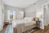 Inviting bedroom with modern decor, featuring a cozy bed with plush pillows, elegant curtains, and warm wooden flooring, exuding comfort and style.
