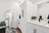 Elegant bathroom showcasing modern black fixtures, crisp white cabinetry, and a stylish full-length mirror.
