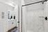 Elegant bathroom featuring sleek white cabinetry, modern fixtures, and luxurious marble tile design.