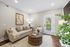Bright and inviting living room with neutral tones, comfortable seating, and elegant decor, featuring a large window with outdoor views.