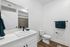 Elegant modern bathroom with a sleek white vanity, stylish fixtures, and rich teal accents providing a fresh, inviting ambience.