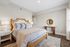 Bright and inviting bedroom with elegant decor, featuring a plush bed, stylish side tables, and tasteful wall art.