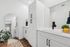 Chic bathroom design featuring elegant white cabinetry, a large mirror, and stylish decor accents.