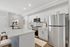 Sleek contemporary kitchen featuring a marble island, stainless steel appliances, and chic white cabinetry with modern accents.