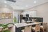 Chic kitchen with sleek marble countertops, modern appliances, and stylish bar seating under elegant recessed lighting.