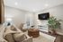 Cozy and inviting living room featuring a beige sofa, wicker coffee table, and stylish decor, perfect for relaxing or entertaining.