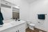 Modern bathroom with sleek fixtures featuring a stylish sink, elegant marble countertop, and luxurious towel set against a chic minimalistic design.