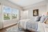 Bright, modern bedroom with elegant decor, featuring large windows offering scenic views and a cozy, inviting atmosphere.