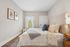 Elegant bedroom with soft neutral tones, featuring a plush bed adorned with patterned pillows, a cozy ambiance, and natural light streaming through sheer curtains.