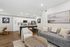 Chic open-plan living room showcasing a modern kitchen with a breakfast bar, stylish dining area, and cozy seating in a bright, inviting space.
